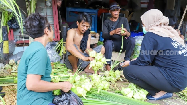 Warga membeli kulit ketupat di Pasar Palmerah, Jakarta, Selasa (9/4/2024). [Suara.com/Alfian Winanto]