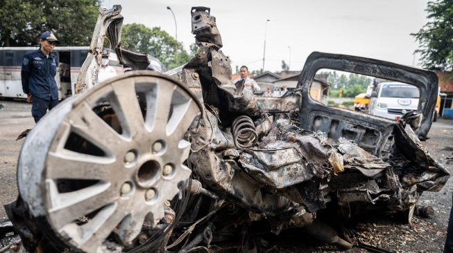Puing-puing mobil Daihatsu Gran Max yang terbakar usai menabrak bus di Tol Cikampek Km 58 pada Senin (8/4/2024). [Antara] 
