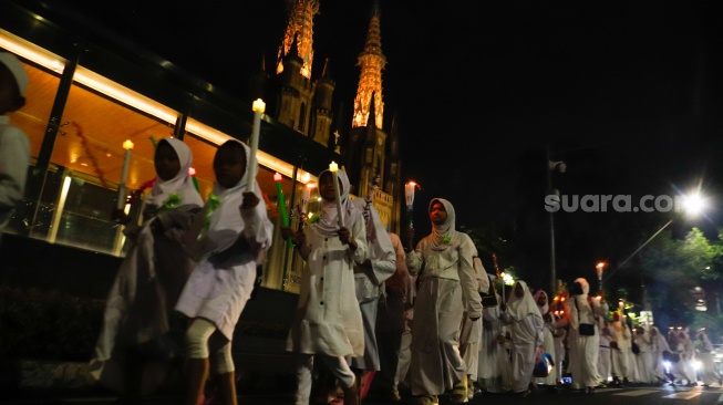 Sejumlah warga melakukan pawai obor malam takbiran di kawasan Masjid Istiqlal, Jakarta, Selasa (9/4/2024). [Suara.com/Alfian Winanto]