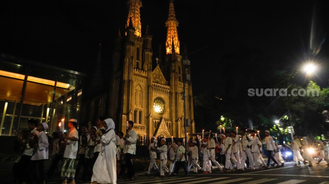 Sejumlah warga melakukan pawai obor malam takbiran di kawasan Masjid Istiqlal, Jakarta, Selasa (9/4/2024). [Suara.com/Alfian Winanto]