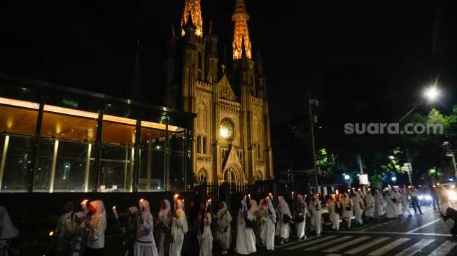 Sejumlah warga melakukan pawai obor malam takbiran di kawasan Masjid Istiqlal, Jakarta, Selasa (9/4/2024). [Suara.com/Alfian Winanto]