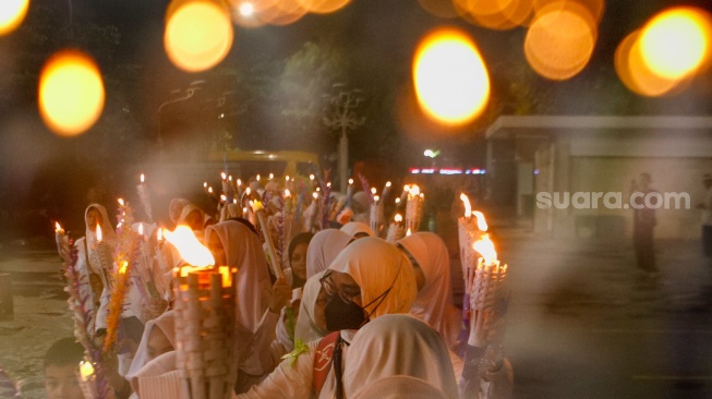 Sejumlah warga melakukan pawai obor malam takbiran di kawasan Masjid Istiqlal, Jakarta, Selasa (9/4/2024). [Suara.com/Alfian Winanto]