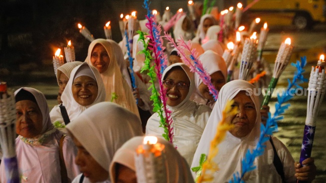 Sejumlah warga melakukan pawai obor malam takbiran di kawasan Masjid Istiqlal, Jakarta, Selasa (9/4/2024). [Suara.com/Alfian Winanto]