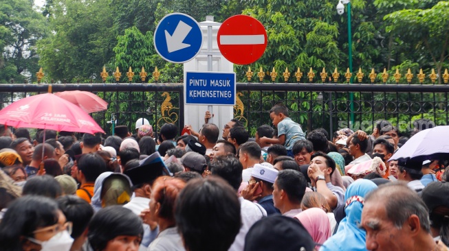 Sejumlah warga mengantre untuk menghadiri open house yang diselenggarkan Presiden Joko Widodo di depan Kantor Kementerian Sekretariat Negara, Jakarta, Rabu (10/4/2024). [Suara.com/Alfian Winanto]