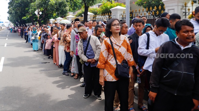 Sejumlah warga mengantre untuk menghadiri open house yang diselenggarkan Presiden Joko Widodo di depan Kantor Kementerian Sekretariat Negara, Jakarta, Rabu (10/4/2024). [Suara.com/Alfian Winanto]