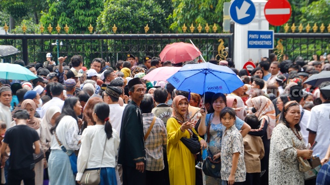 Sejumlah warga mengantre untuk menghadiri open house yang diselenggarkan Presiden Joko Widodo di depan Kantor Kementerian Sekretariat Negara, Jakarta, Rabu (10/4/2024). [Suara.com/Alfian Winanto]