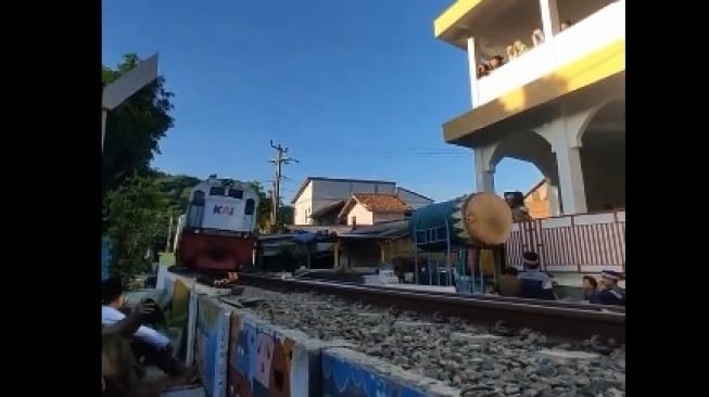 Tetap Khusyuk, Viral Kereta Api Lewat di Tengah-tengah Jemaah Salat Idul Fitri. [tangkapan layar dari X]