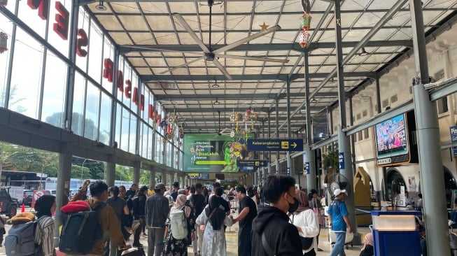 Pemudik tiba di Stasiun Pasar Senen, Senin (15/4/2024). KAI Daop 1 Jakarta memrediksi hari ini menjadi puncak arus balik Lebaran 2024. [Suara.com/Dea]