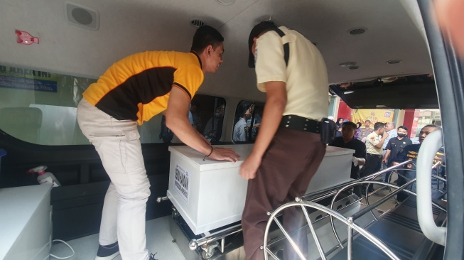 Petugas memindahkan peti jenazah korban kecelakaan di KM 58 Tol Japek yang telah diidentifikasi. [Suara.com/Faqih]