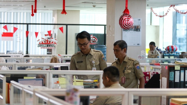 Aparatur sipil negara (ASN) beraktivitas saat hari pertama kerja di gedung Balaikota DKI Jakarta, Selasa (16/4/2024). [Suara.com/Alfian Winanto]