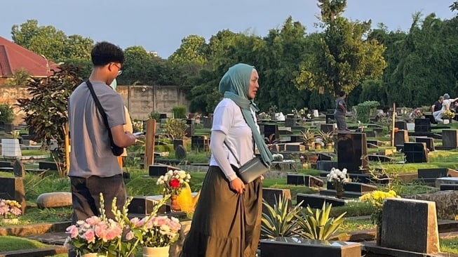 Potret Angelina Sondakh Ziarah ke Makam Adjie Massaid. (Instagram/angelinasondakh09)