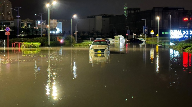 Kendaraan terdampar di jalan yang terendam banjir menyusul hujan lebat di Dubai, Uni Emirat Arab, Rabu (17/4/2024).  [Giuseppe CACACE / AFP]