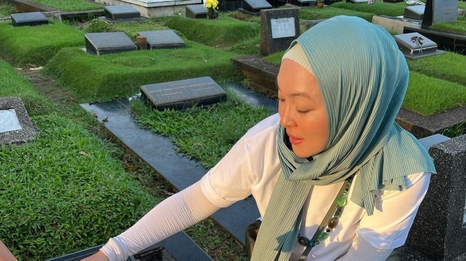 Potret Angelina Sondakh Ziarah ke Makam Adjie Massaid. (Instagram/angelinasondakh09)