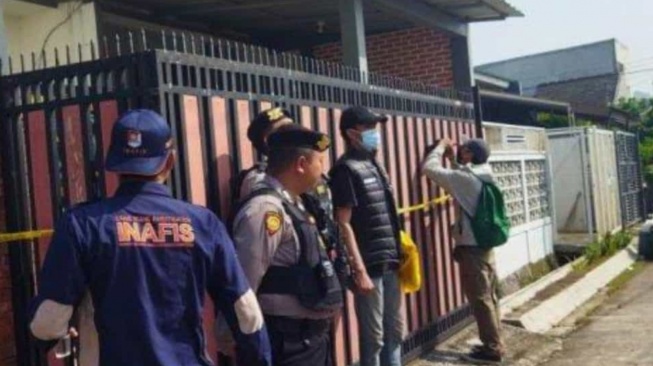 Polisi melakukan pengamanan di depan sebauh rumah yang menjadi lokasi penemuan sesosok mayat di sebuah komplek perumahan di Bandung Barat, Jawa Barat. Foto: Harapanrakyat.com