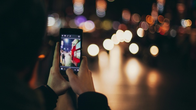 Ilustrasi mengambil foto di malam hari. [Unsplash/Clem Onojeghuo]