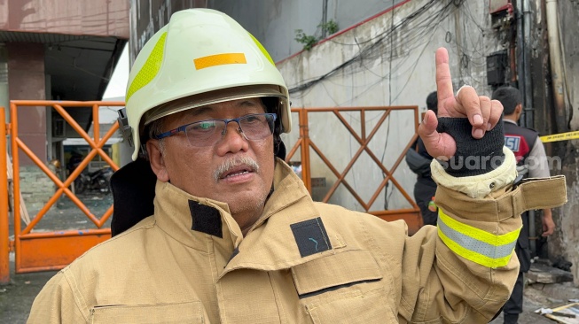 Perwira Piket Suku Dinas Penanggulangan Kebakaran dan Penyelamatan atau Sudin Gulkarmat Jakarta Selatan, Agus Guritno Gunawan saat ditemui awak media di lokasi kebakaran ruko Saudara Frame di Mampang Prapatan yang menewaskan tujuh orang. (Suara.com/M Yasir)