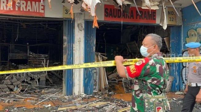 Penampakan aparat gabungan saat memasang police line di Ruko Saudara Frame dan Gallery, di Jalan Mampang Prapatan Raya, Jakarta Selatan usai ludes terbakar dan menewaskan tujuh korban jiwa. (Suara.com/M Yasir)