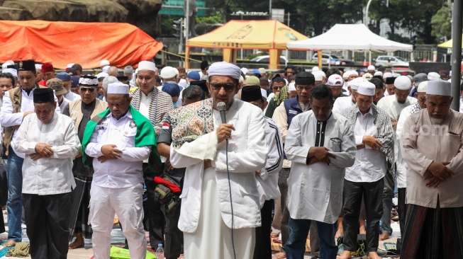 Massa menggelar salat jumat berjamaah saat aksi tolak pemilu curang di Patung Kuda, Jakarta, Jumat (19/4/2024). [Suara.com/Alfian Winanto]