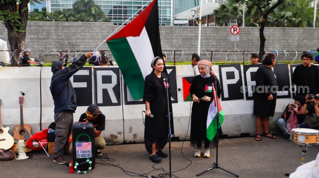 Penyanyi Chiki Fawzi dan Bella Fawzi tampil saat aksi solidaritas untuk Palestina di depan Kantor Kedutaan Besar Amerika Serikat, Jakarta, Jumat (19/4/2024). [Suara.com/Alfian Winanto]