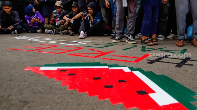 Sejumlah membuat pop art saat menggelar aksi solidaritas untuk Palestina di depan Kantor Kedutaan Besar Amerika Serikat, Jakarta, Jumat (19/4/2024). [Suara.com/Alfian Winanto]
