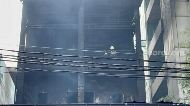 Lima lantai bangunan Ruko Saudara Frame dan Gallery di Jalan Mampang Prapatan Raya, Jakarta Selatan gosong akibat kebakaran yang terjadi pada Kamis (18/4/2024) malam. (Suara.com/M. Yasir)