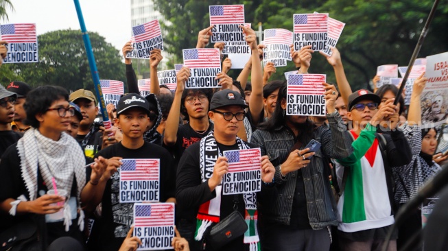 Sejumlah massa mengangkat poster saat menggelar aksi solidaritas untuk Palestina di depan Kantor Kedutaan Besar Amerika Serikat, Jakarta, Jumat (19/4/2024). [Suara.com/Alfian Winanto]