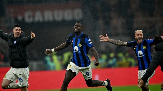 Striker Inter Milan Marcus Thuram (tengah) bersama pemain Inter lainnya merayakan kemenangan usai memastikan timnya merengkuh scudetto ke-20 dalam laga melawan tuan rumah AC Milan dengan kemenangan 2-1, Selasa (23/4/2024). (Foto: AFP)