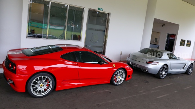 Penampakan dua mobil mewah berjenis Ferrari (merah) dan satu Mercedes Benz (putih) milik suami Sandra Dewi, Harvey Moeis, yang disita jaksa penyidik dan ditempatkan di depan Gedung Kartika Kejaksaan Agung, Jakarta, Jumat (26/4/2024). [Suara.com/Alfian Winanto]