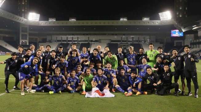 Para pemain Jepang berfoto saat merayakan kemenangan usai pertandingan semifinal Piala Asia U23 2024 antara Jepang melawan Irak di Stadion Jassim Bin Hamad, Doha, Qatar, Senin (29/4/2024). [Karim JAAFAR / AFP]