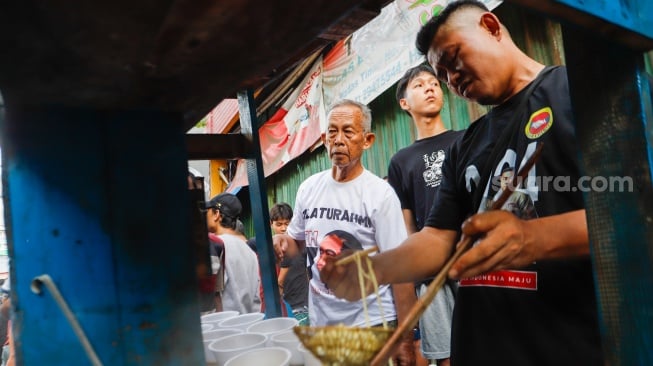 Warga mengantre mie ayam gratis di wilayah Menteng Wadas Timur, Jakarta, Selasa (30/4/2024). [Suara.com/Alfian Winanto]