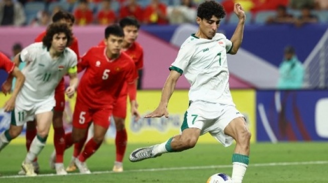 Penyerang Irak Ali Jasim mencetak gol dari titik penalti pada pertandingan perempat final Piala Asia U-23 2024 antara Irak dan Vietnam di Stadion Al-Janoub di Doha pada 26 April 2024. KARIM JAAFAR / AFP