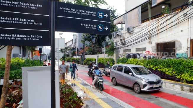 Warga berjalan melewati kawasan Transport Hub Dukuh Atas, Jakarta, Selasa (30/4/2024). [Suara.com/Alfian Winanto]