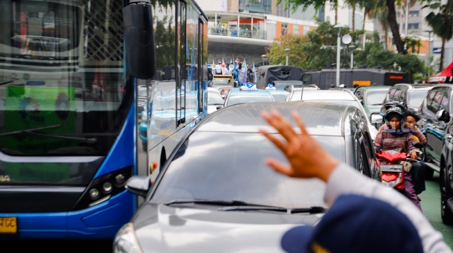 Sejumlah kendaraan terjebak kemacetan di kawasan Bundaran HI, Jakarta, Rabu (1/5/2024). [Suara.com/Alfian Winanto]