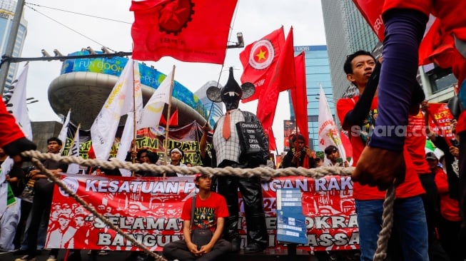 Massa Buruh dari berbagai elemen melakukan aksi unjuk rasa untuk memperingati Hari Buruh atau May Day di kawasan Bundaran HI, Jakarta, Rabu (1/5/2024). [Suara.com/Alfian Winanto]