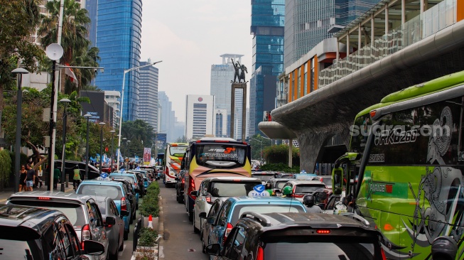 Sejumlah kendaraan terjebak kemacetan di kawasan Bundaran HI, Jakarta, Rabu (1/5/2024). [Suara.com/Alfian Winanto]