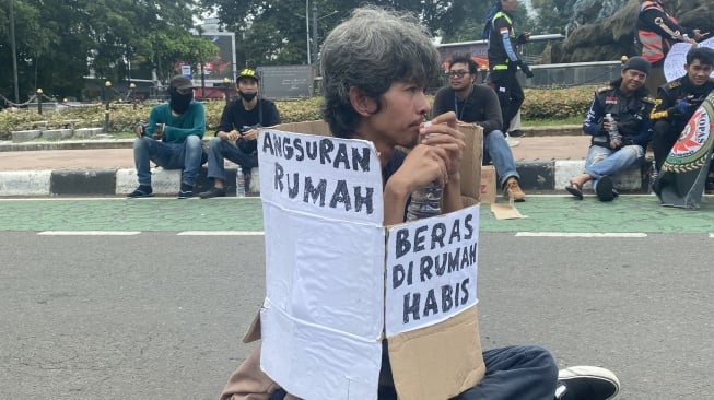 Seorang peserta aksi yang menggelar demo Hari Buruh di Kawasan Patung Kuda Jalan Medan Merdeka, Jakarta pada Rabu (1/5/2024). [Suara.com/Faqih] 