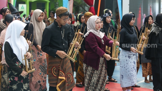 Pelajar memakai pakaian adat saat menampilkan pertunjukan seni di SMKN 38, Jakarta, Kamis (2/5/2024). [Suara.com/Alfian Winanto]
