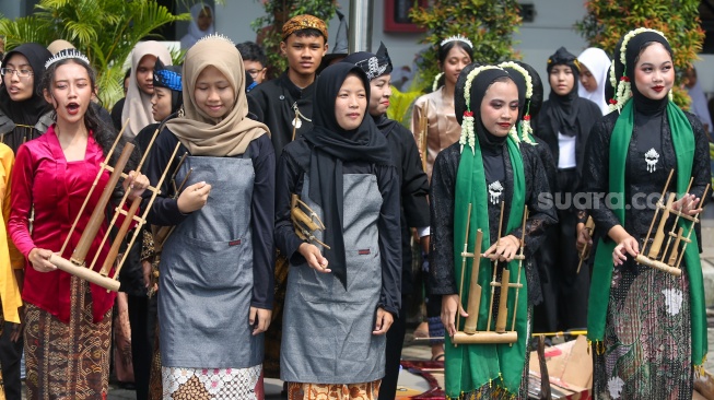 Pelajar memakai pakaian adat saat menampilkan pertunjukan seni di SMKN 38, Jakarta, Kamis (2/5/2024). [Suara.com/Alfian Winanto]
