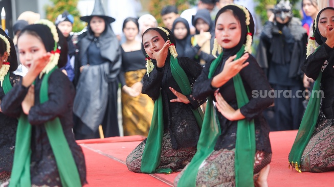 Pelajar memakai pakaian adat saat menampilkan pertunjukan seni di SMKN 38, Jakarta, Kamis (2/5/2024). [Suara.com/Alfian Winanto]
