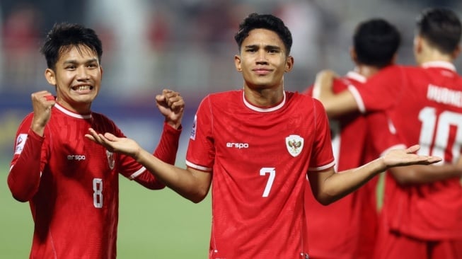 Gelandang Timnas Indonesia U-23, Marselino Ferdinan (tengah) melakukan selebrasi bersama rekannya setelah mencetak gol pertama timnya melalui tendangan penalti dalam pertandingan Grup A Piala Asia AFC U23 melawan Yordania di Stadion Abdullah Bin Khalifa di Doha pada 21 April 2024.KARIM JAAFAR / AFP.