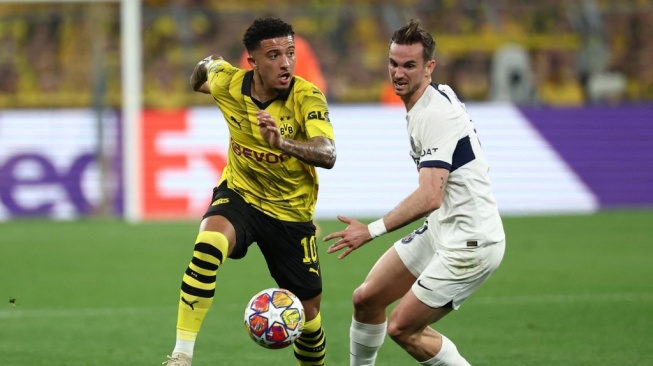 Gelandang Borussia Dortmund, Jadon Sancho (kiri) berebut bola dengan gelandang Paris Saint-Germain (PSG) Fabian Ruiz selama pertandingan leg pertama semifinal Liga Champions 2023-2024 antara Borussia Dortmund vs Paris Saint-Germain (PSG) di Dortmund , Jerman bagian barat pada 1 Mei 2024.FRANCK FIFE / AFP.