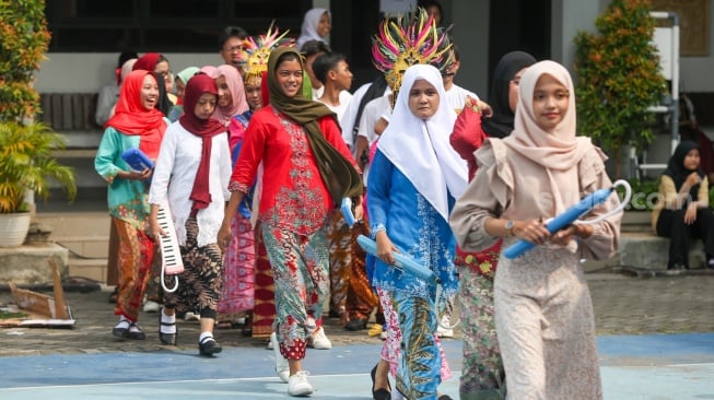 Pelajar memakai pakaian adat saat menampilkan pertunjukan seni di SMKN 38, Jakarta, Kamis (2/5/2024). [Suara.com/Alfian Winanto]
