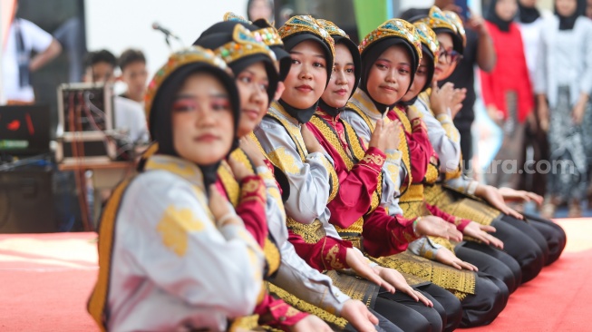 Pelajar memakai pakaian adat saat menampilkan pertunjukan seni di SMKN 38, Jakarta, Kamis (2/5/2024). [Suara.com/Alfian Winanto]
