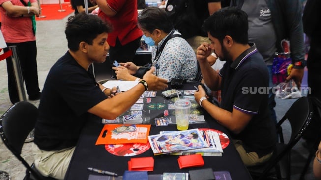 Pengunjung bermain Trading Card Game (TCG) di gelaran Anime Festival Asia Indonesia (AFAID) di  JCC Senayan, Jakarta, Jumat (3/5/2024). [Suara.com/Alfian Winanto]