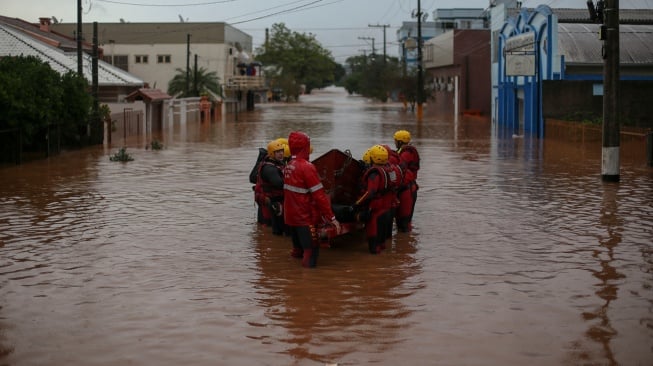 Tim pemadam kebakaran bekerja di jalan yang banjir di pusat kota Sao Sebastiao do Cai, Rio Grande do Sul, Brasil, Kamis (2/5/2024). [Anselmo Cunha / AFP] 