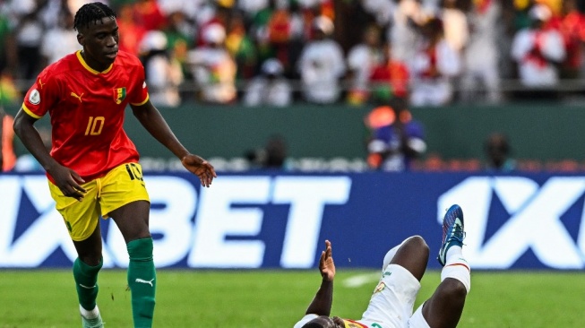 Gelandang Senegal Nampalys Mendy (kanan) bereaksi setelah terjatuh di samping gelandang Guinea Ilaix Moriba selama pertandingan sepak bola grup C Piala Afrika (CAN) 2024 antara Guinea dan Senegal di Stade Charles Konan Banny di Yamoussoukro pada 23 Januari 2024 .Issouf SANOGO / AFP