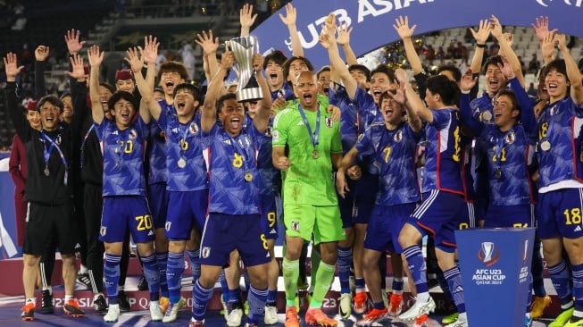 Para pemain Jepang selebrasi dan mengangkat trofi setelah memenangkan pertandingan final Piala Asia U23 2024 antara Jepang melawan Uzbekistan di Stadion Jassim Bin Hamad, Doha, Qatar, Jumat (3/5/2024). [KARIM JAAFAR / AFP]