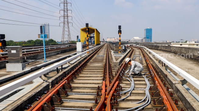 Pekerja melakukan pengecekan arus listrik pada jalur Light Rail Transit (LRT) Jakarta di Depo LRT Jakarta Pegangsaan Dua, Jakarta, Rabu (8/5/2024). [Suara.com/Alfian Winanto]