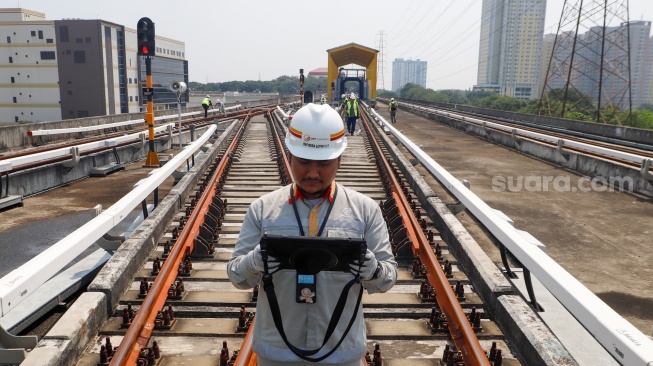 Pekerja melakukan pengecekan sistem lampu persinyalan pada jalur Light Rail Transit (LRT) Jakarta di Depo LRT Jakarta Pegangsaan Dua, Jakarta, Rabu (8/5/2024). [Suara.com/Alfian Winanto]