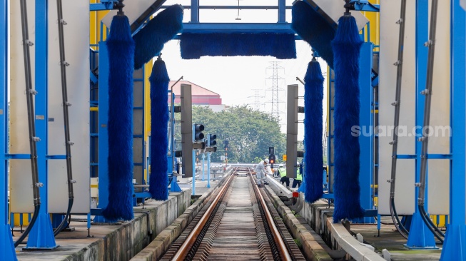 Pekerja melakukan pengecekan Automatic Train Washing Point (ATWP) pada jalur Light Rail Transit (LRT) Jakarta di Depo LRT Jakarta Pegangsaan Dua, Jakarta, Rabu (8/5/2024). [Suara.com/Alfian Winanto]